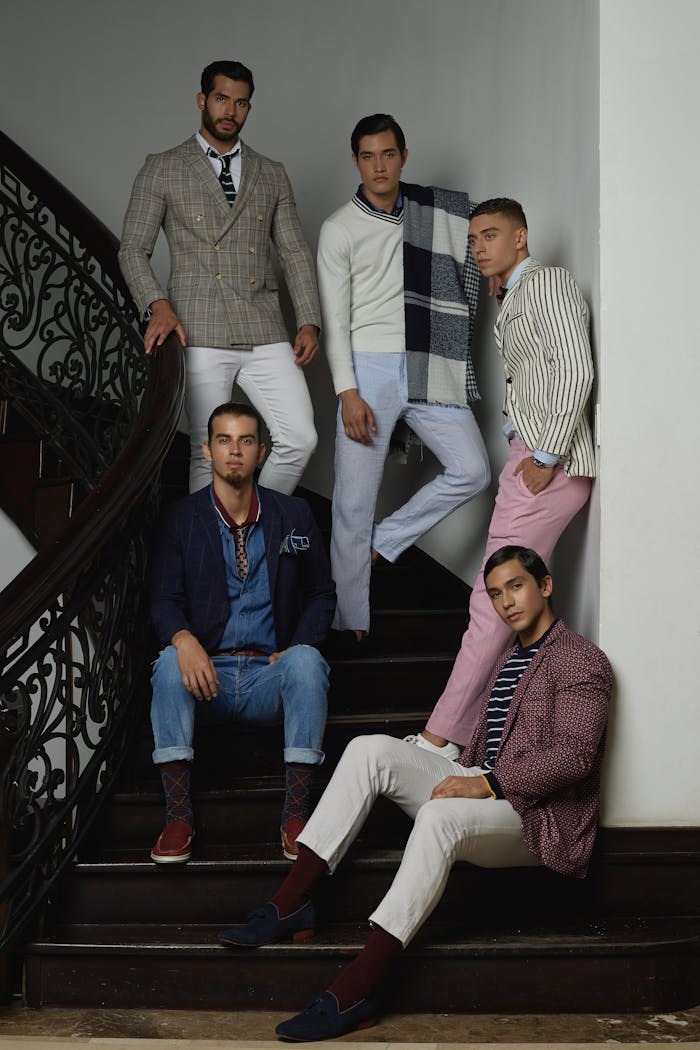 Stylish group of men showcasing casual elegance on a classic staircase setting.